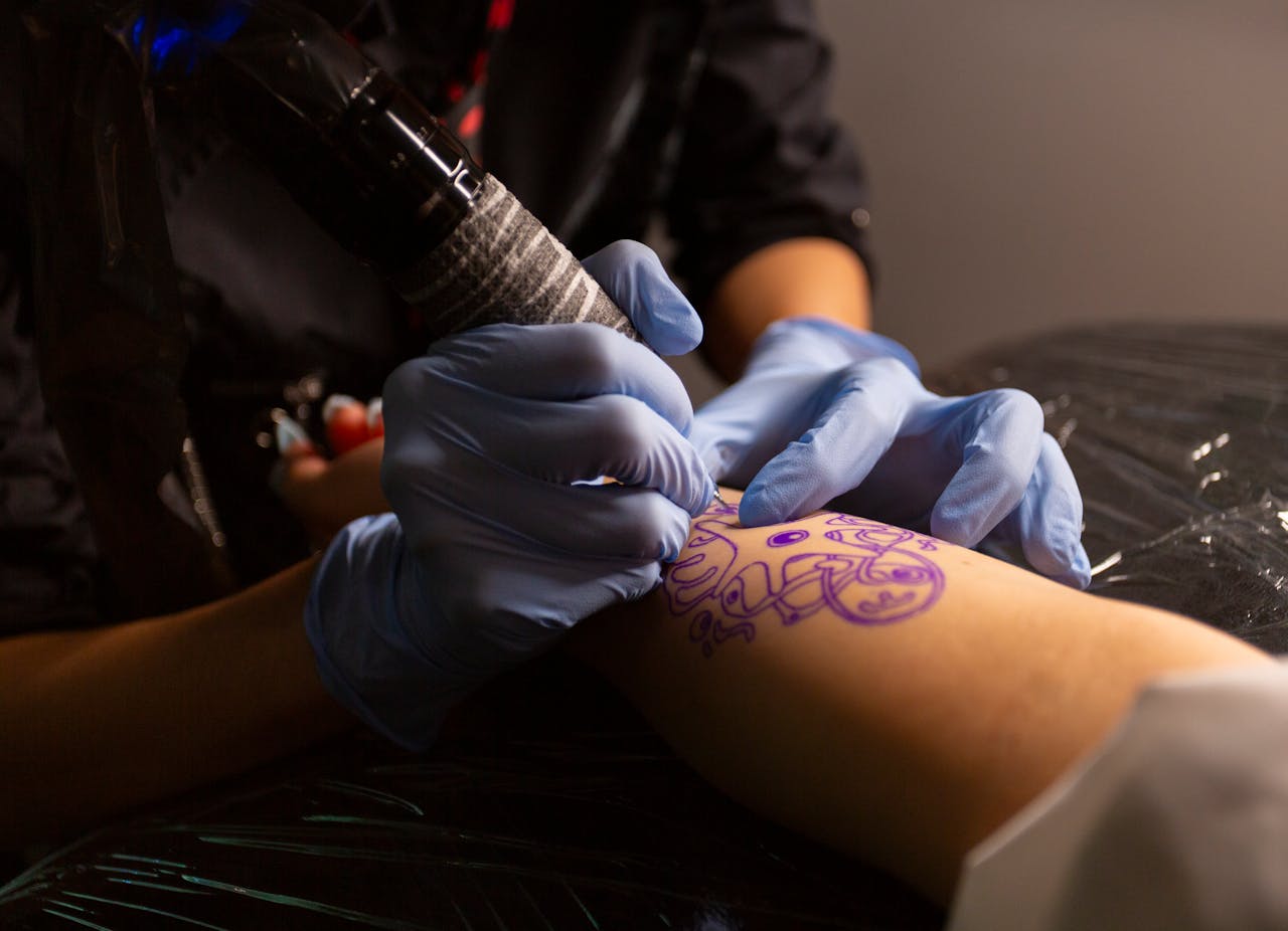 Tattoo artist in Shinjuku creating a detailed design on a client's arm, showcasing precision in a cozy studio.