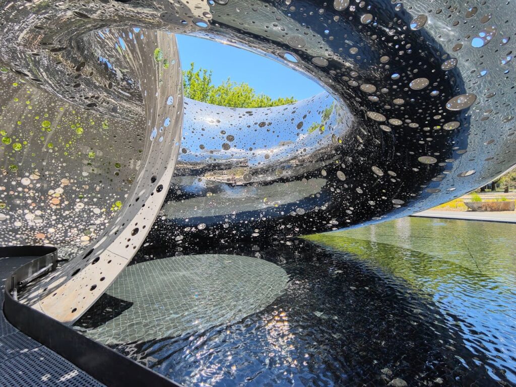 Sculptural water feature with metallic reflections in Canberra, Australia.